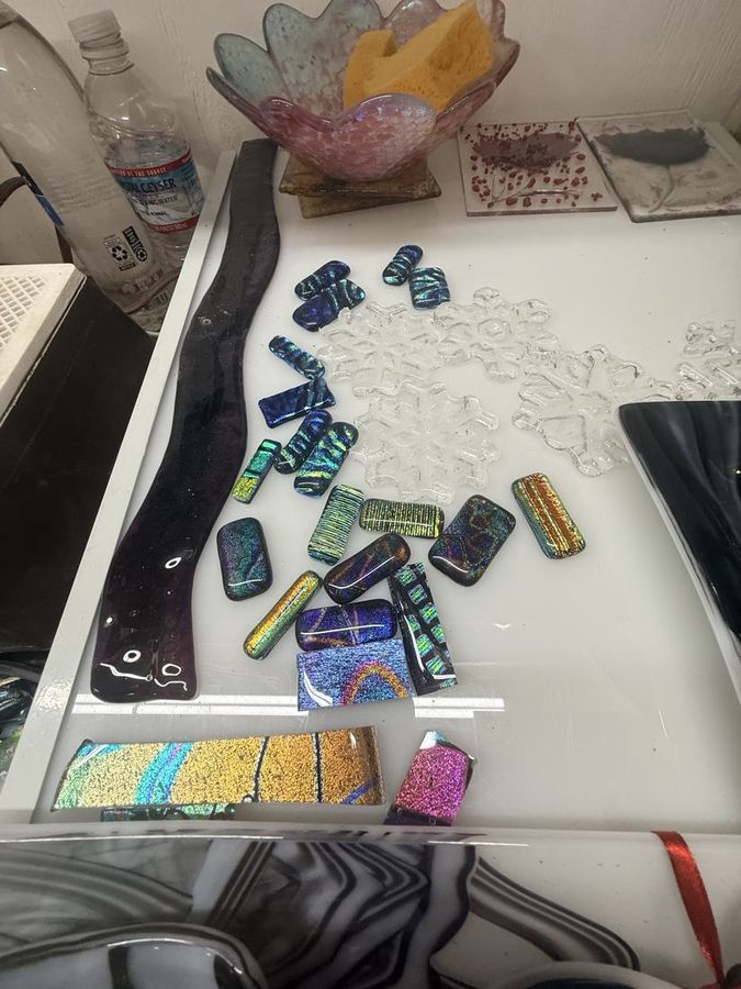 Cut dichroic glass laid out on the bench